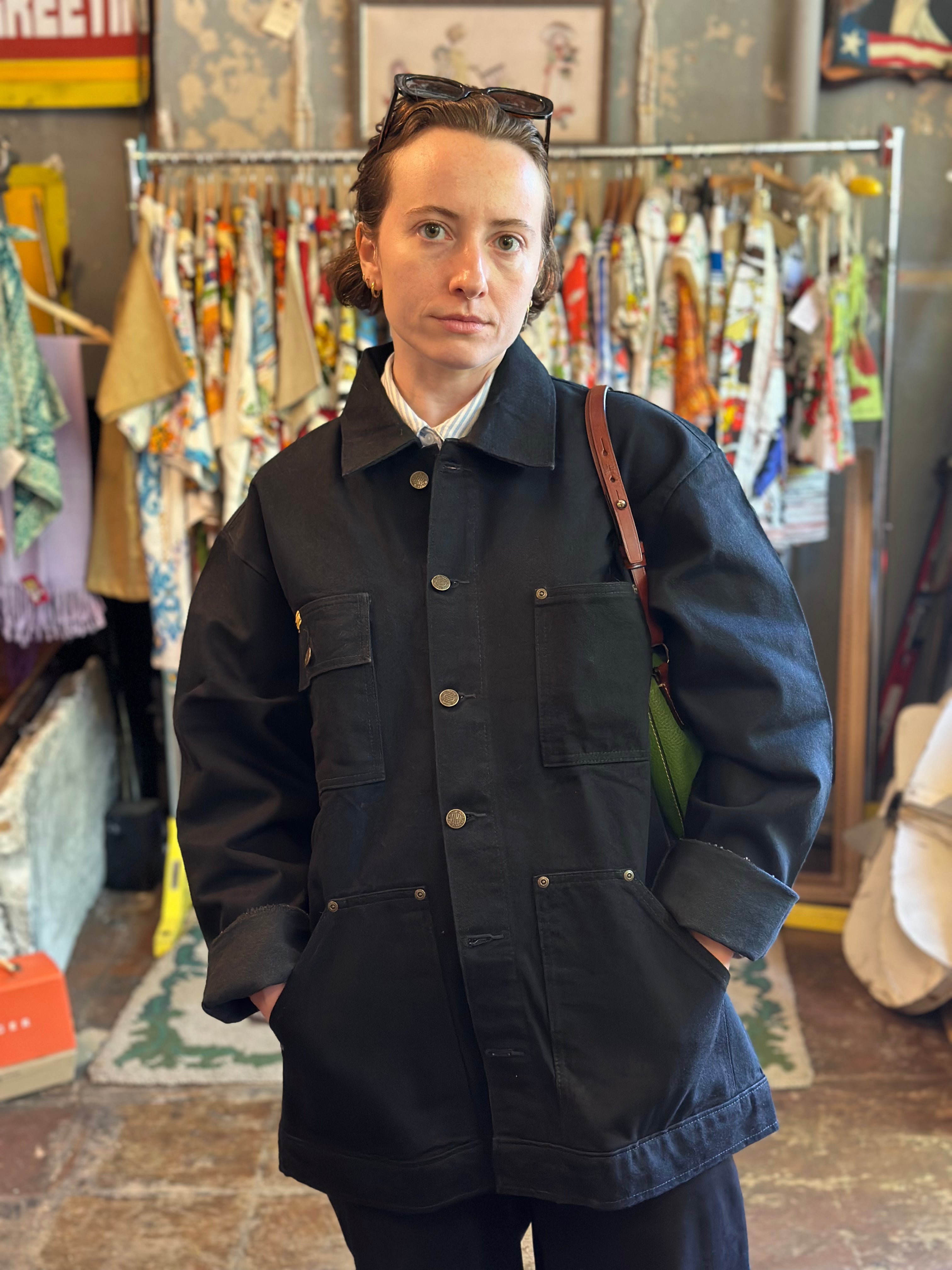Person wearing a dark coat in a vintage store setting