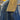 Close-up of a blue denim jacket with a yellow collar and a blurred background