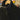 Black coat on a wooden hanger against a blurred background with signs and posters.